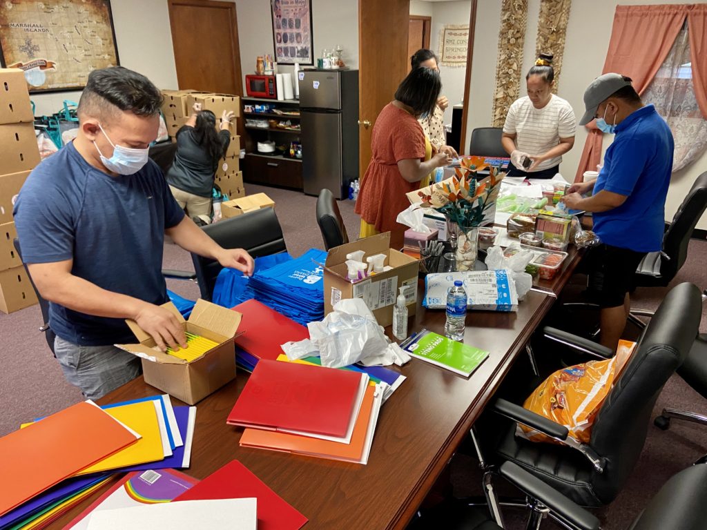 Photo of Marshallese Education Initiative workers preparing school supplies in an office