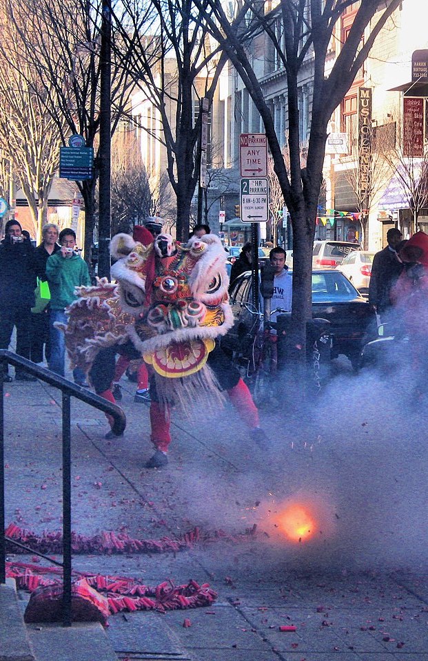 Photo of Chinese lion dancers and a firecracker as part of a celebration in Philadelphia's Chinatown.