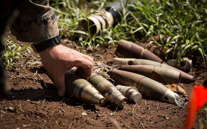 An explosive ordnance disposal technician piles up a group of 60-millimeter mortars at Kaneohe Bay Range Training Facility on March 2, 2017. Photo courtesy of the U.S. Marine Corps.