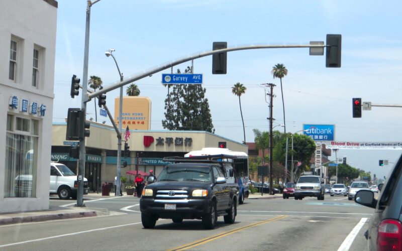 Photo of a black car driving down Garvey Avenue in Monterey Park, where many Asian Americans host shops and businesses.