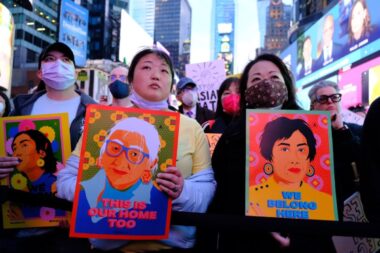 Photo of demonstrators holding signs that denounce anti-Asian hate as they gather in Times Square for a memorial of the Atlanta spa shootings.