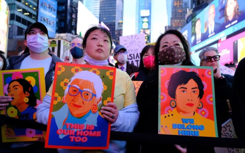 Photo of demonstrators holding signs that denounce anti-Asian hate as they gather in Times Square for a memorial of the Atlanta spa shootings.