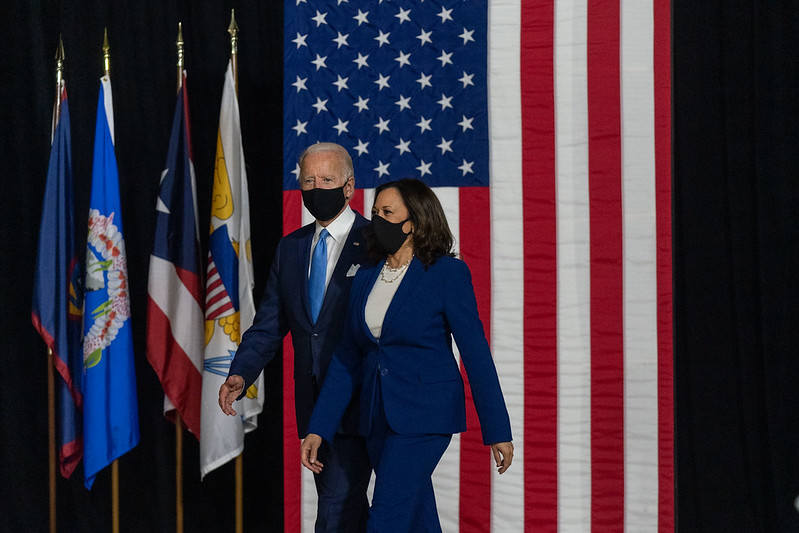 Photo of Joe Biden and Kamala Harris walking on to a stage
