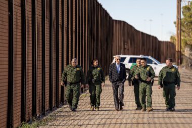 Photo of Joe Biden walking with law enforcement officers along the U.S.'s border wall