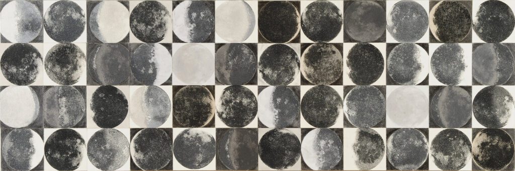 Photo of an art piece showing the various different phases of the moon in black and white.
