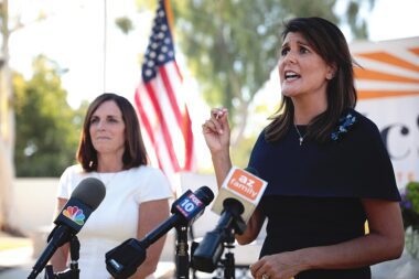 Photo of Nikki Haley speaking into a bundle of different news mics