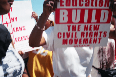 Photo of demonstrators holding signs in support of affirmative action at a rally.