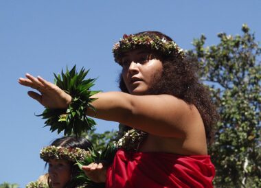 Photo of a woman participating in a Hula kahiko performance.