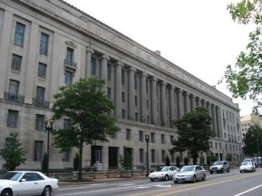 Photo of the exterior of the DOJ building next to a street