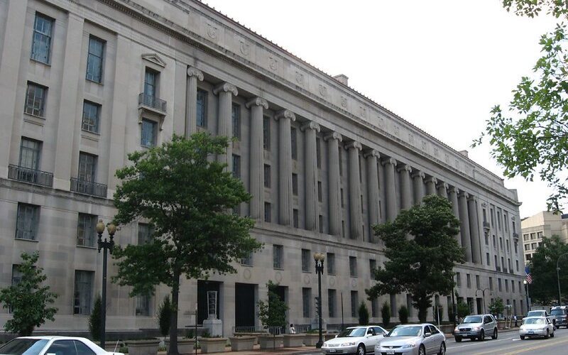 Photo of the exterior of the DOJ building next to a street