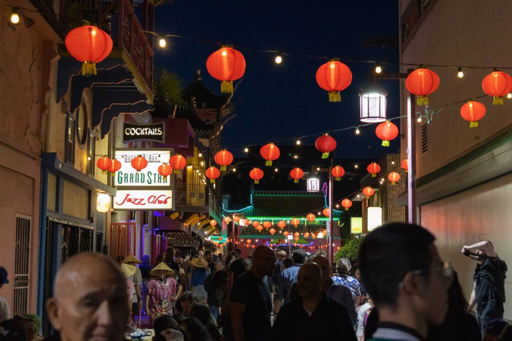 Photo of an alleyway in Los Angeles Chinatown showing red lanterns and art stands