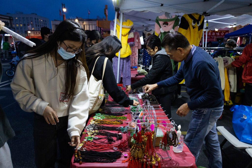 Photo of people browsing jewelry at a night market