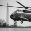 Black and white photo of a helicopter against the backdrop of the Washington Monunment