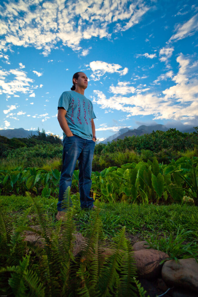 Photo of Pellegrino standing amongst his land on Nohoʻana Farm.