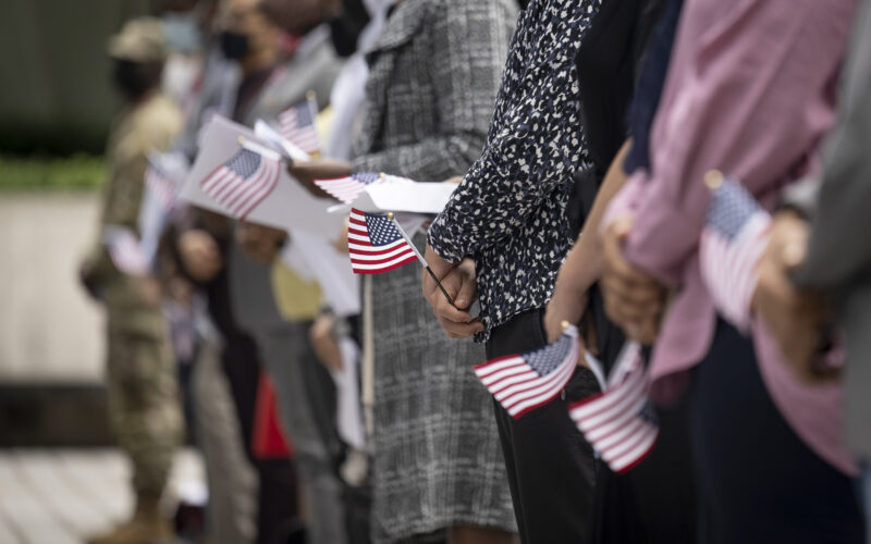 Photo of a naturalization ceremony on Citizenship Day, showing a row of people holding U.S. flags
