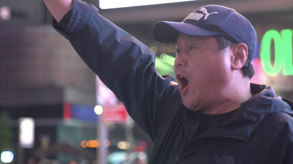 Photo of Juntao Wang raising his arm in a protest with other Chinese dissidents