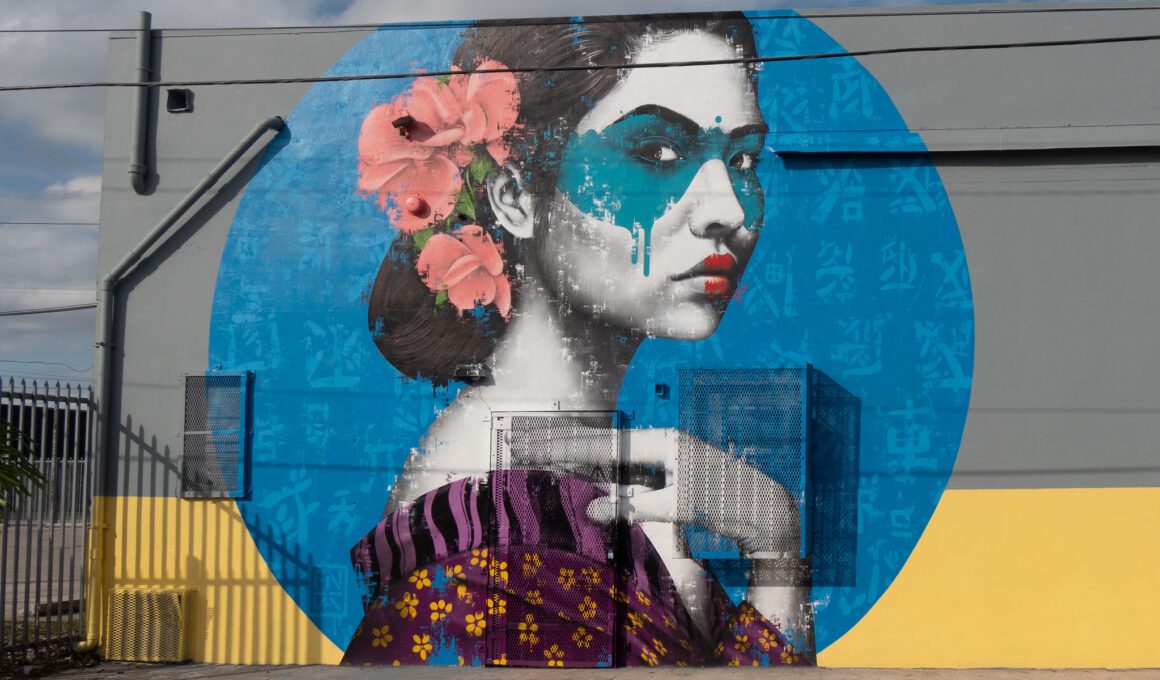 Photo of an art mural depicting an Asian woman wearing a blue eye mask in a Florida neighborhood