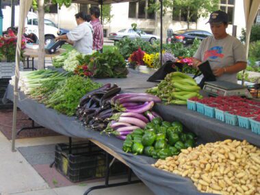 Photo of Asian Americans at an outdoor farmers' market selling groceries in Milwaukee, Wisconsin