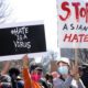 Photo of two protesters holding signs that say "#HateIsAVirus" and "Stop Asian Hate"