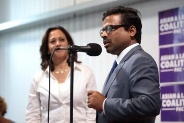 Photo of a woman watching a man speak into a microphone at an event in Iowa