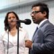 Photo of a woman watching a man speak into a microphone at an event in Iowa